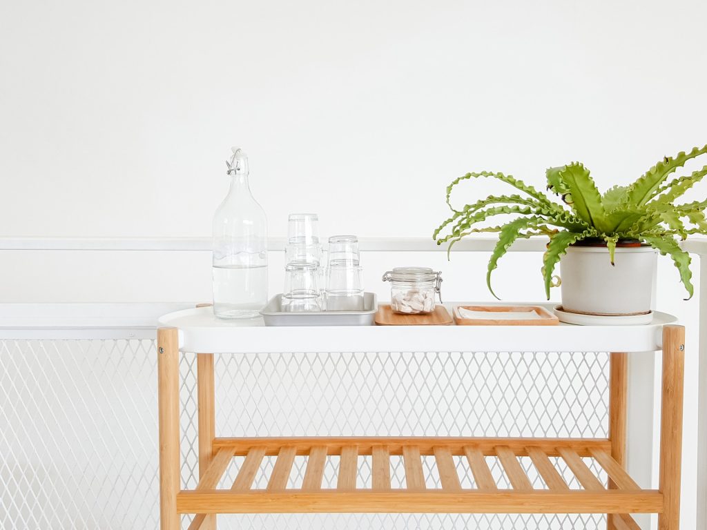 Desserte en bois avec verres et plante, logement entretenu avec des produits écologiques